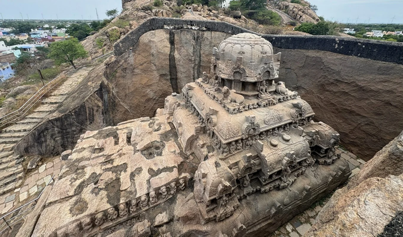 Monolithic rock-cut temple carved into bedrock quarry trench.