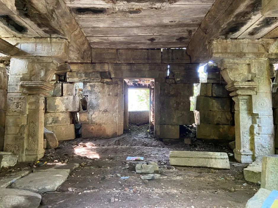 Interior stone doorway threshold in a historic temple looking outwards toward natural daylight.